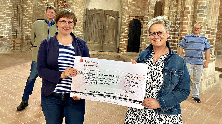 Pfarrerin Sophie Ludwig nahm den Scheck aus den Händen der Vorstandsvorsitzenden des Uckermärkischen Konzertchores, Peggy Boldt (rechts), im Beisein weiterer Sänger entgegen. (Foto: Claudia Marsal)